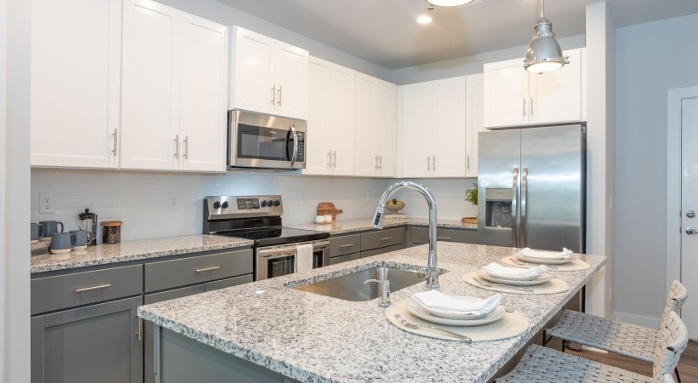 A kitchen with granite countertop and stainless steel appliances.