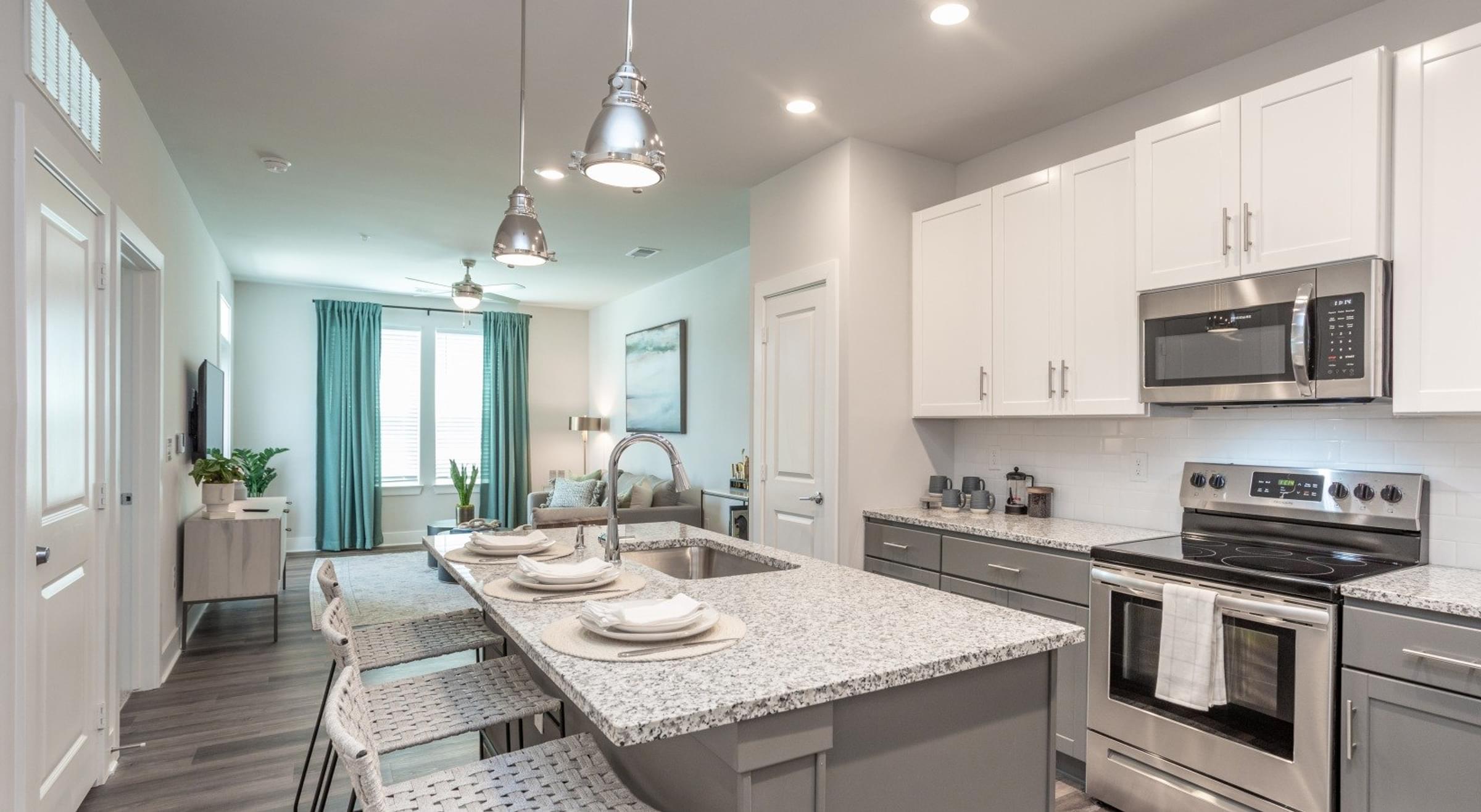 Kitchen with Bar Seating and a View of the Living Room.