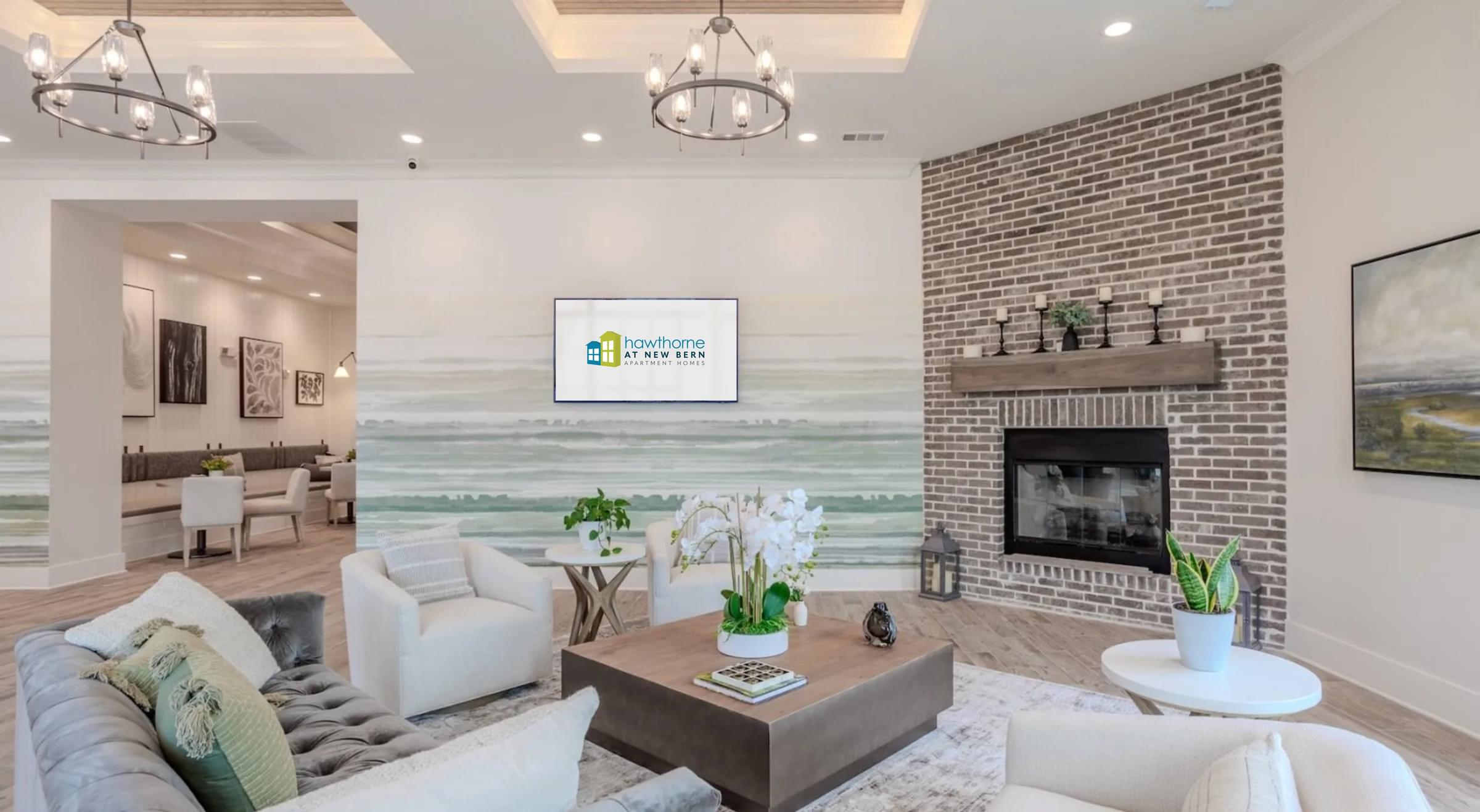 A modern clubhouse with a fireplace and a large painting on the wall at Hawthorne at New Bern in New Bern, NC
