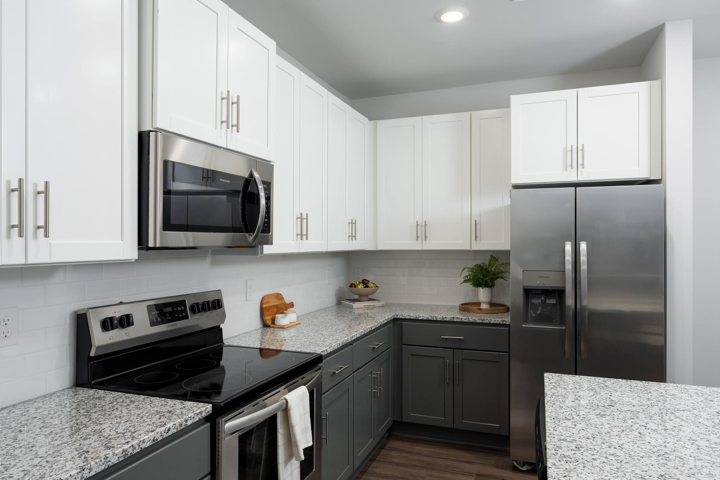 A modern kitchen with a stove top oven, microwave, and refrigerator.