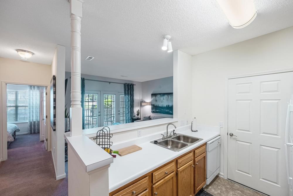 an open kitchen and living room with a sink and a window