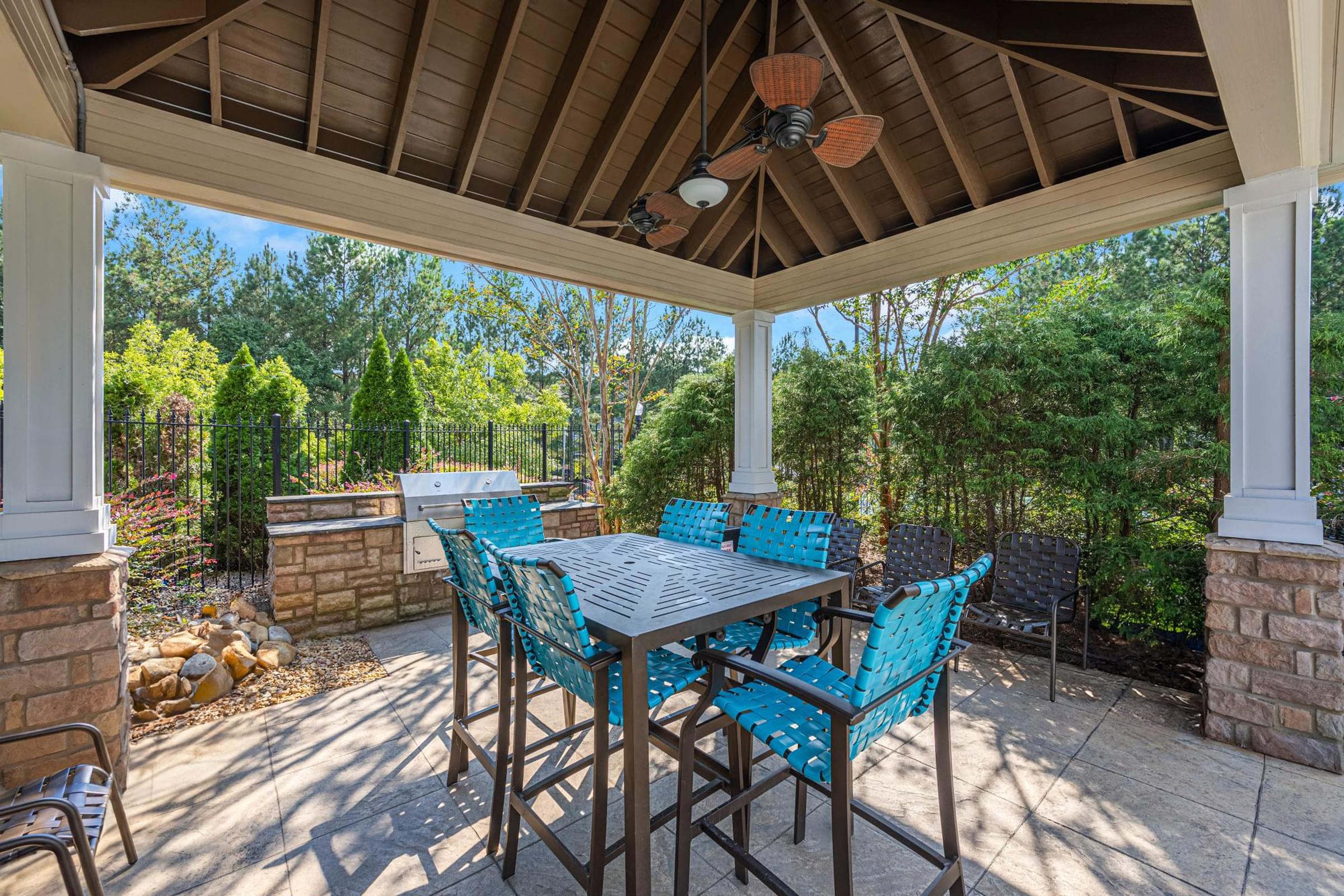 a covered patio with a dining table and chairs