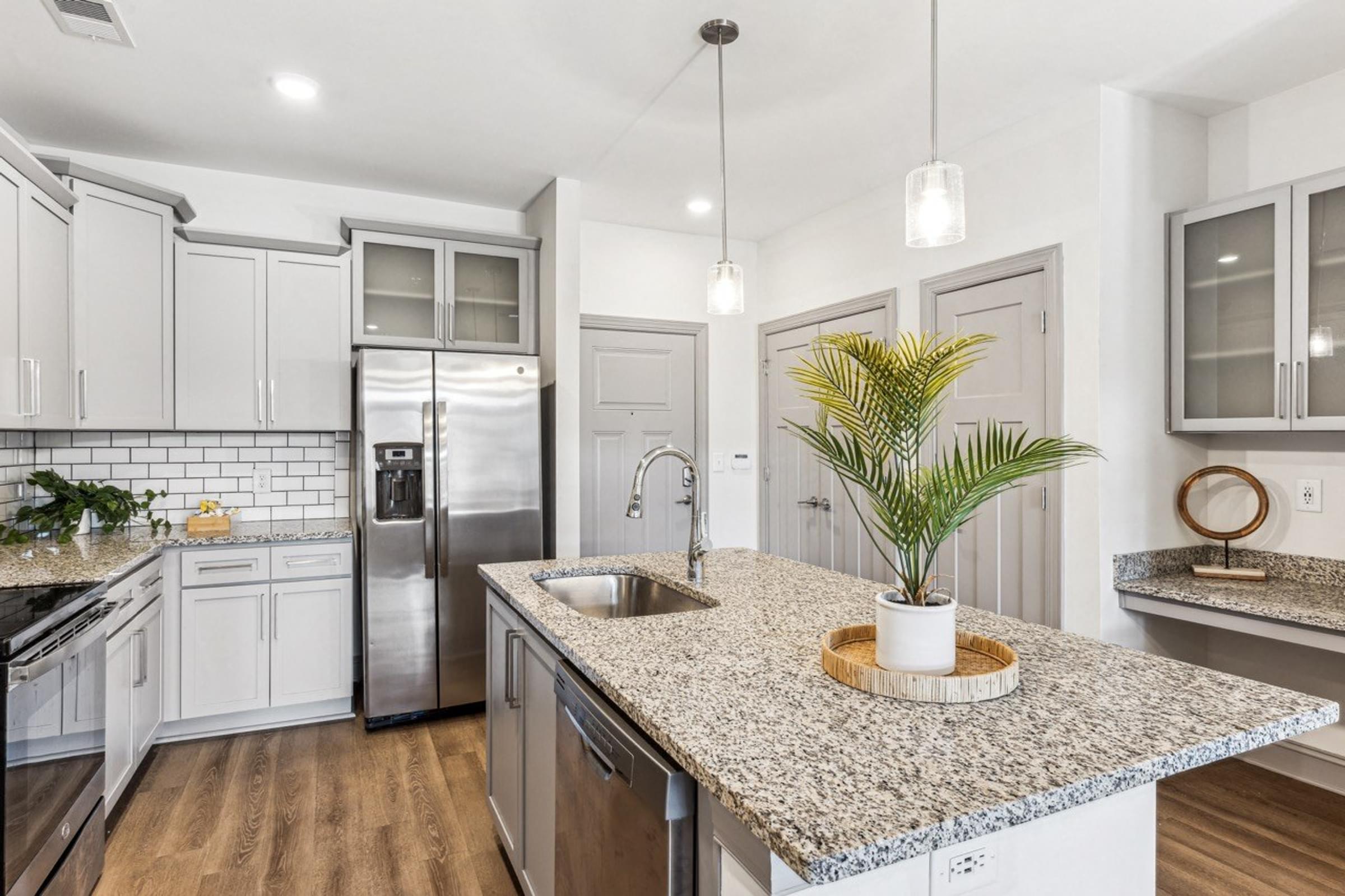 a kitchen with granite counter tops and stainless steel appliances