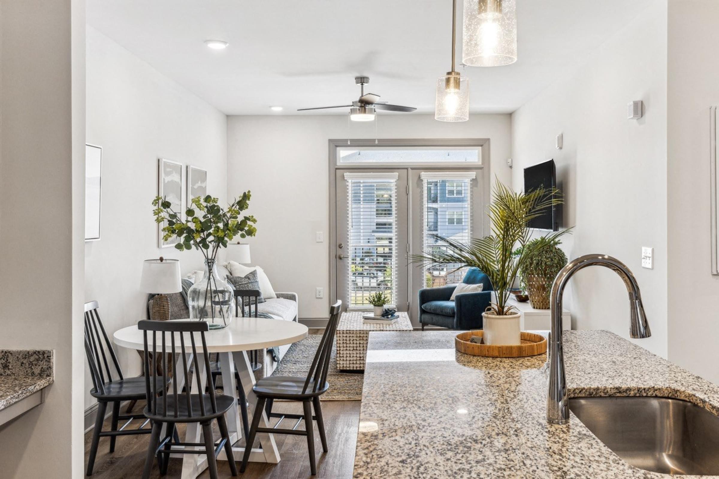an open kitchen and living room with a dining room table and a sink