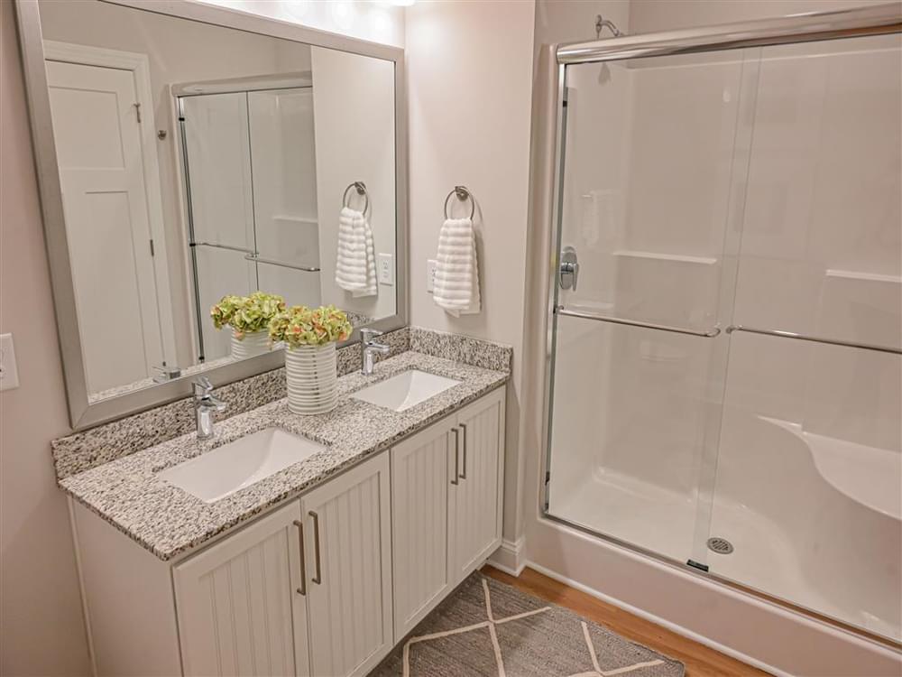 a bathroom with two sinks and a shower