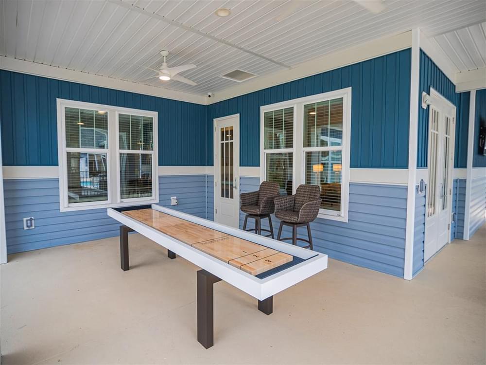 a pool table in the porch of a blue house