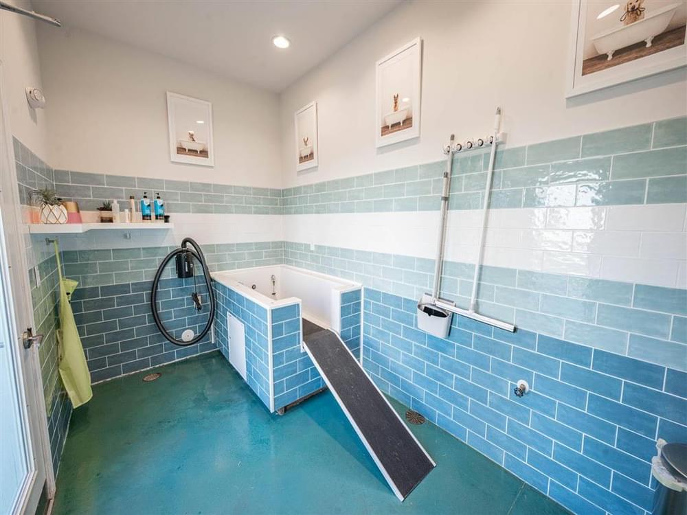 a bathroom with a tub and a shower and blue tiles