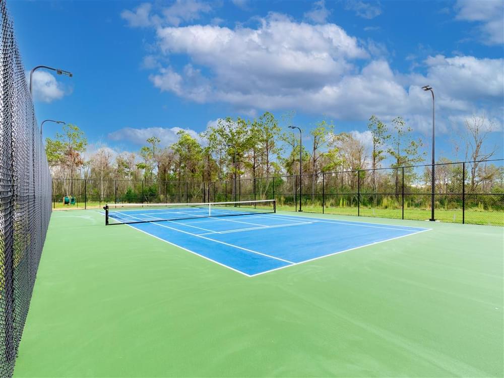 a blue and green tennis court with a fence around it