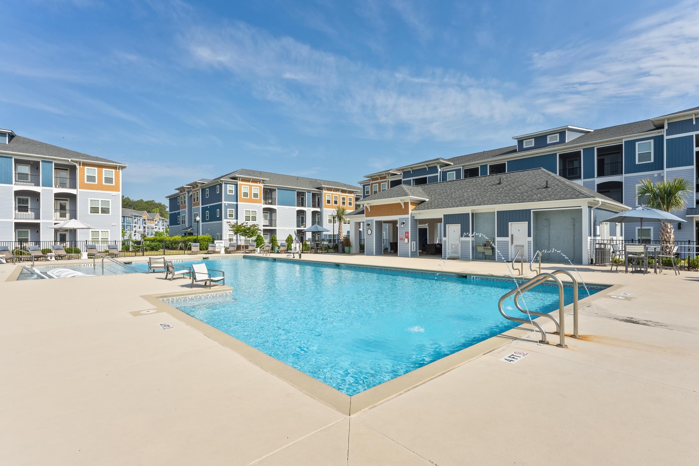 A swimming pool in front of apartment buildings.