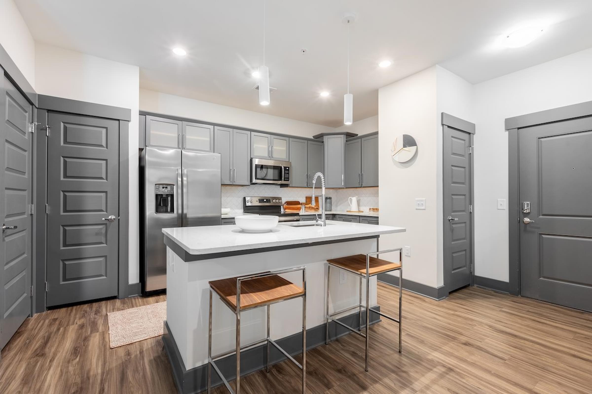 a kitchen with a large island and stainless steel appliances