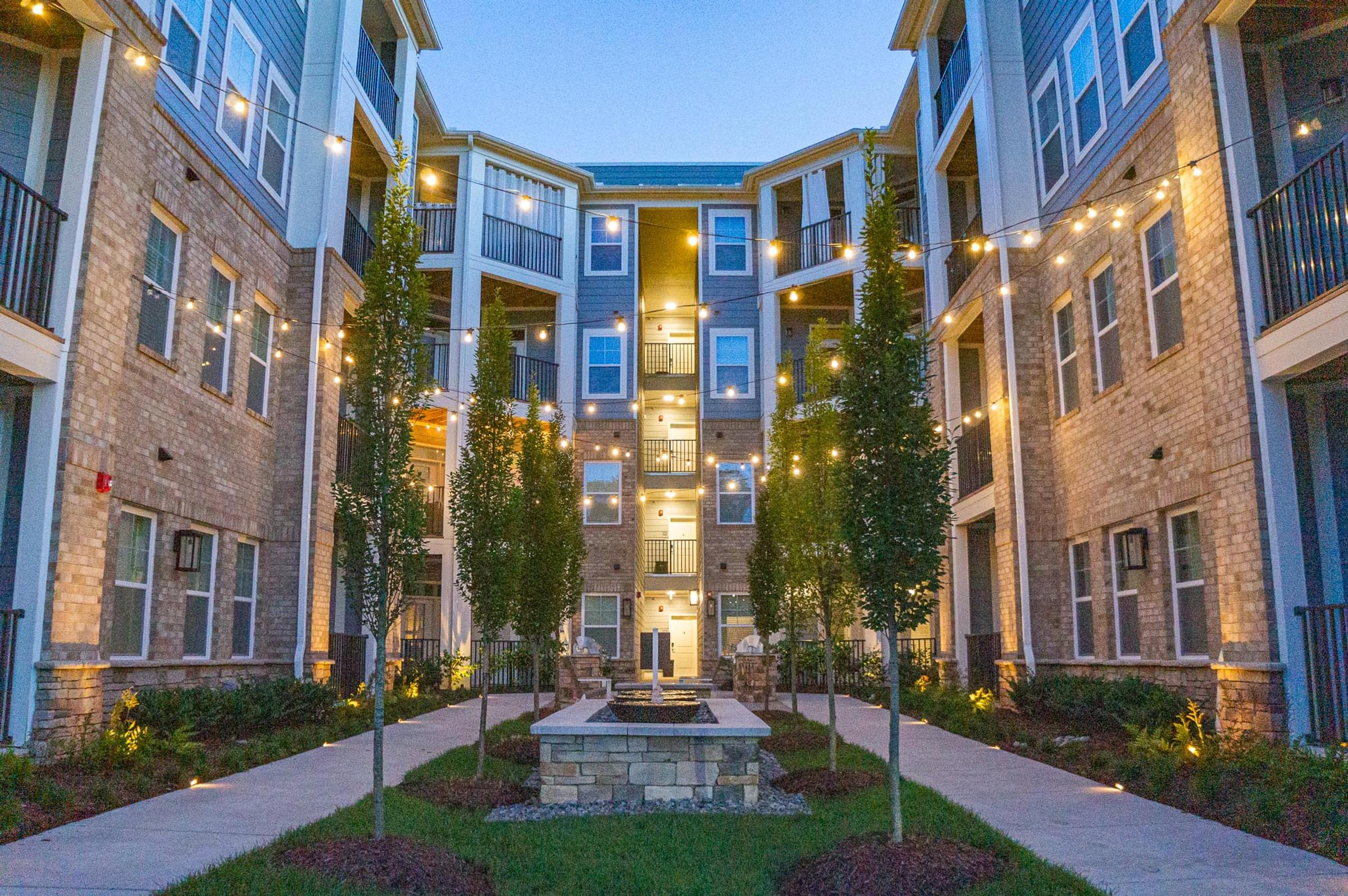 a courtyard with a fountain in the middle of an apartment building