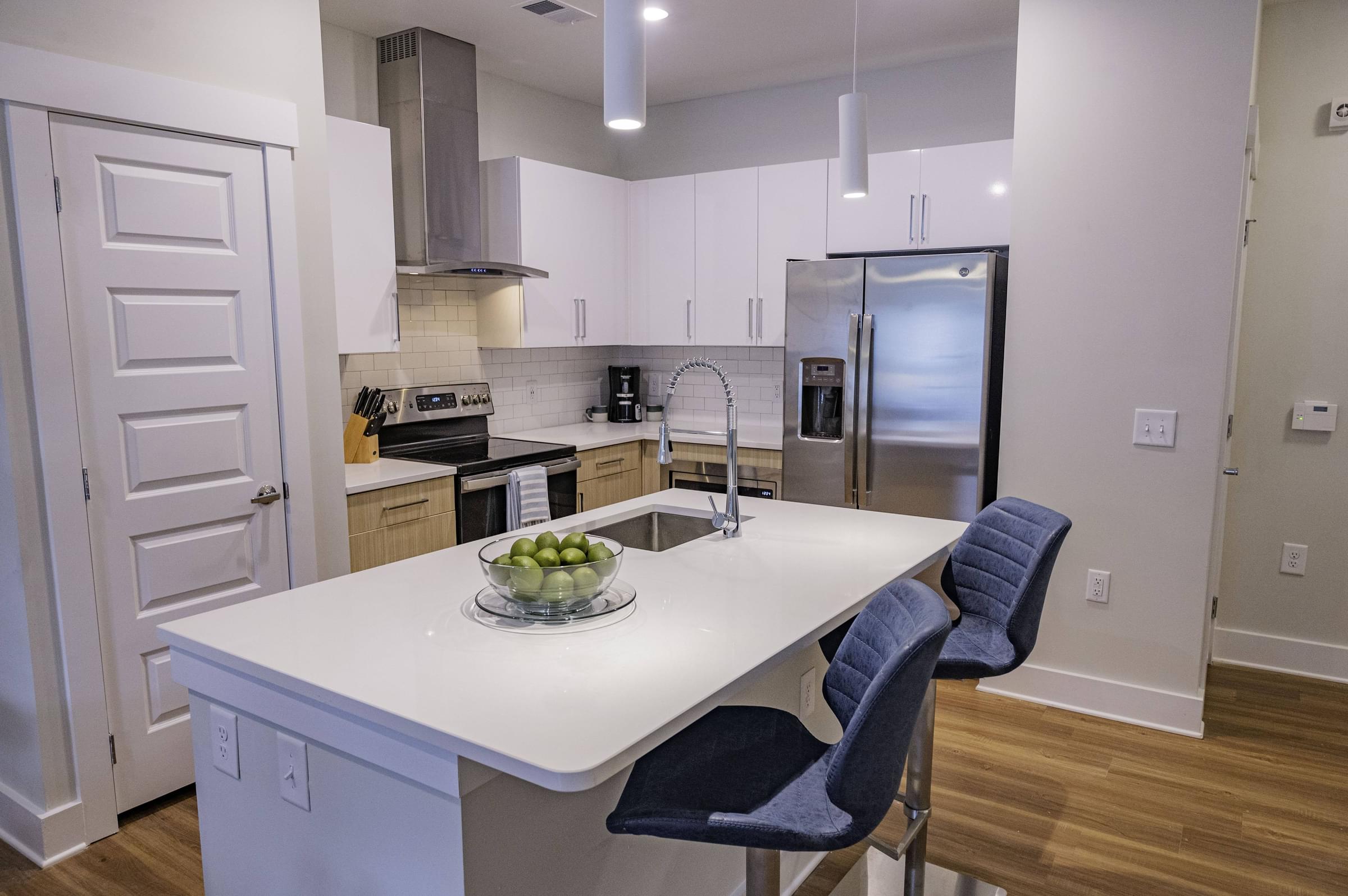 Modern Kitchen with Stand-Alone Island and Breakfast Bar with Quartz Countertops, Energy Efficient Appliances, and Large Pantry