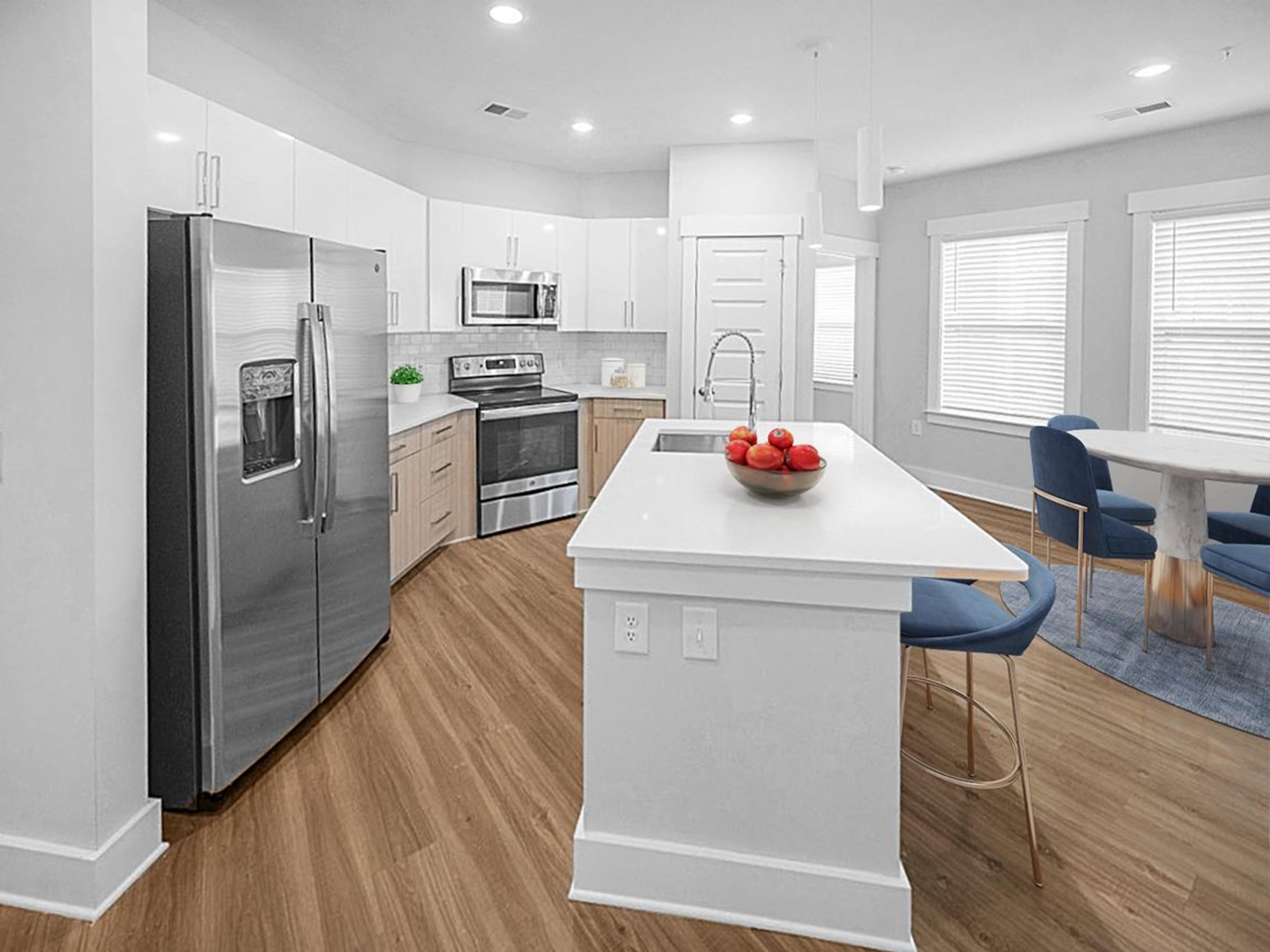 a kitchen with a large island and a stainless steel refrigerator