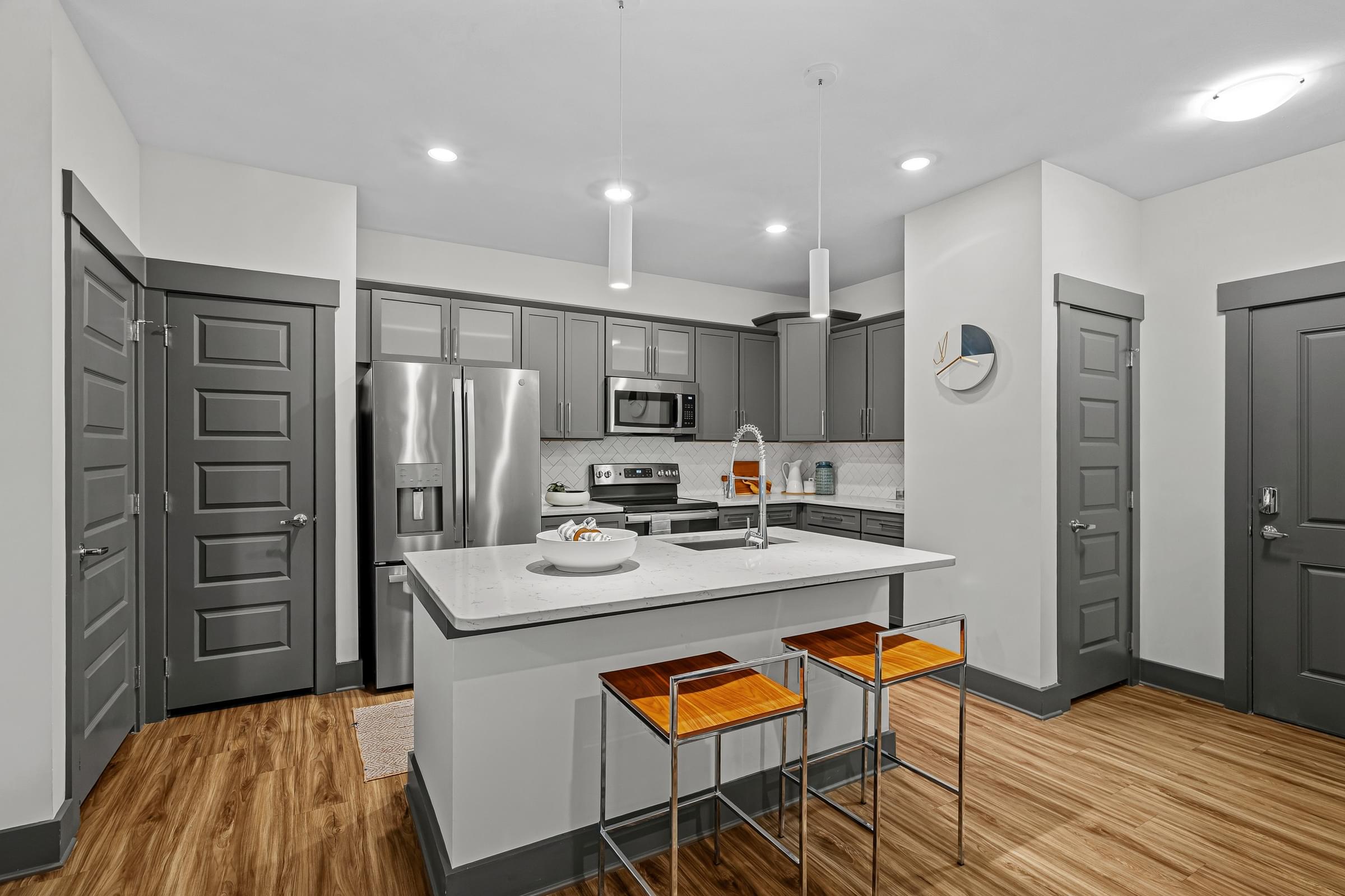 Modern Kitchen with Stand-Alone Island and Breakfast Bar with Quartz Countertops, Energy Efficient Appliances, and Large Pantry