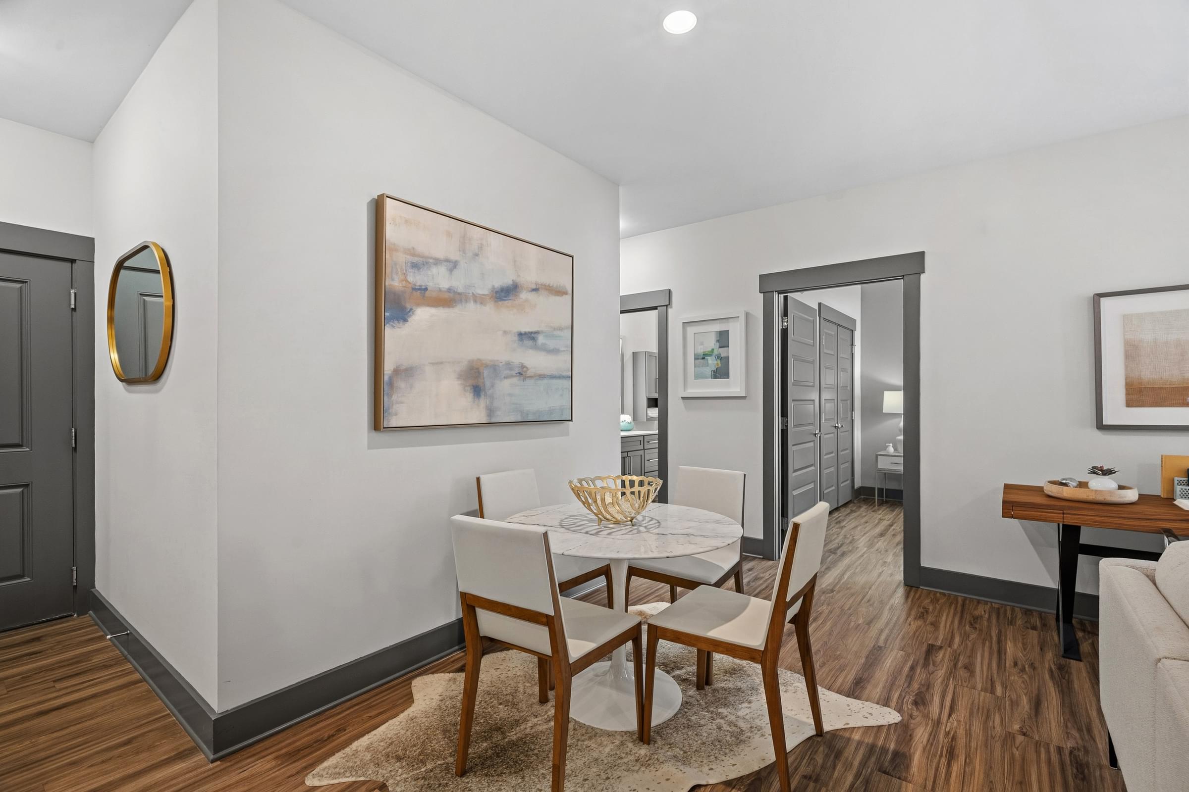A dining room with a white table and chairs.