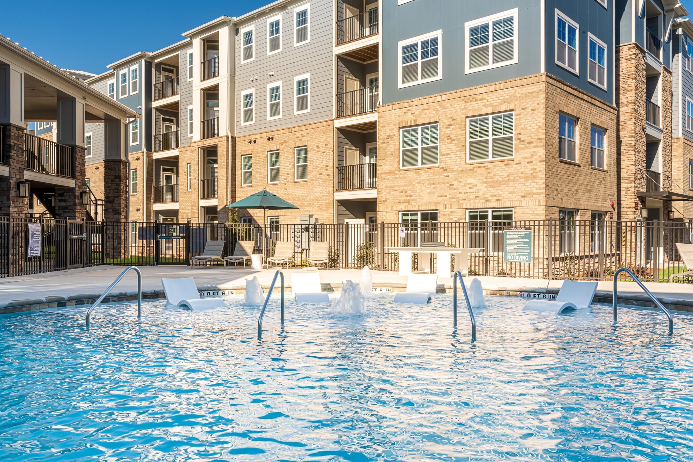 a swimming pool in front of an apartment building