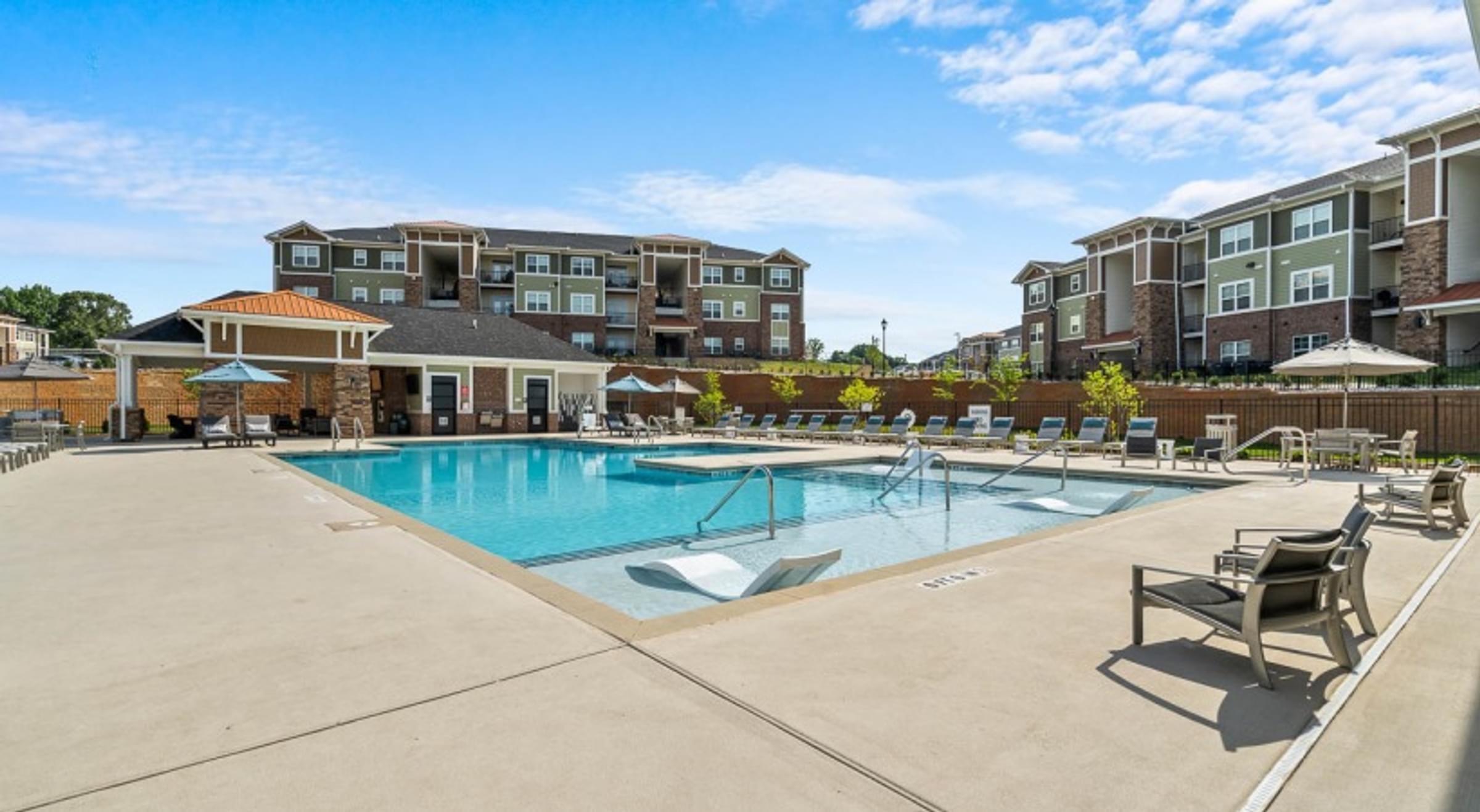 Amenities Highlight luxurious pool with small fountains, lounge seating, and cabanas