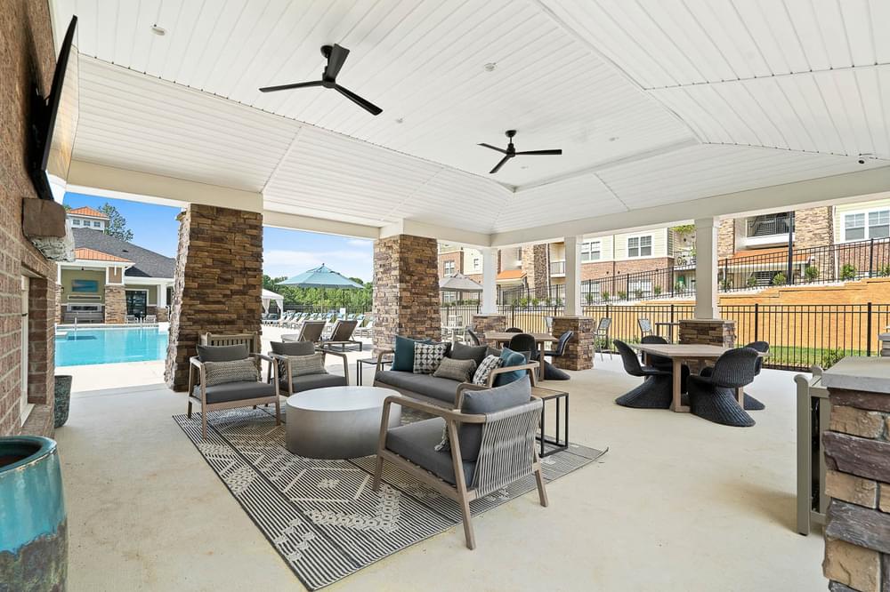 the clubhouse has a large patio with furniture and a pool