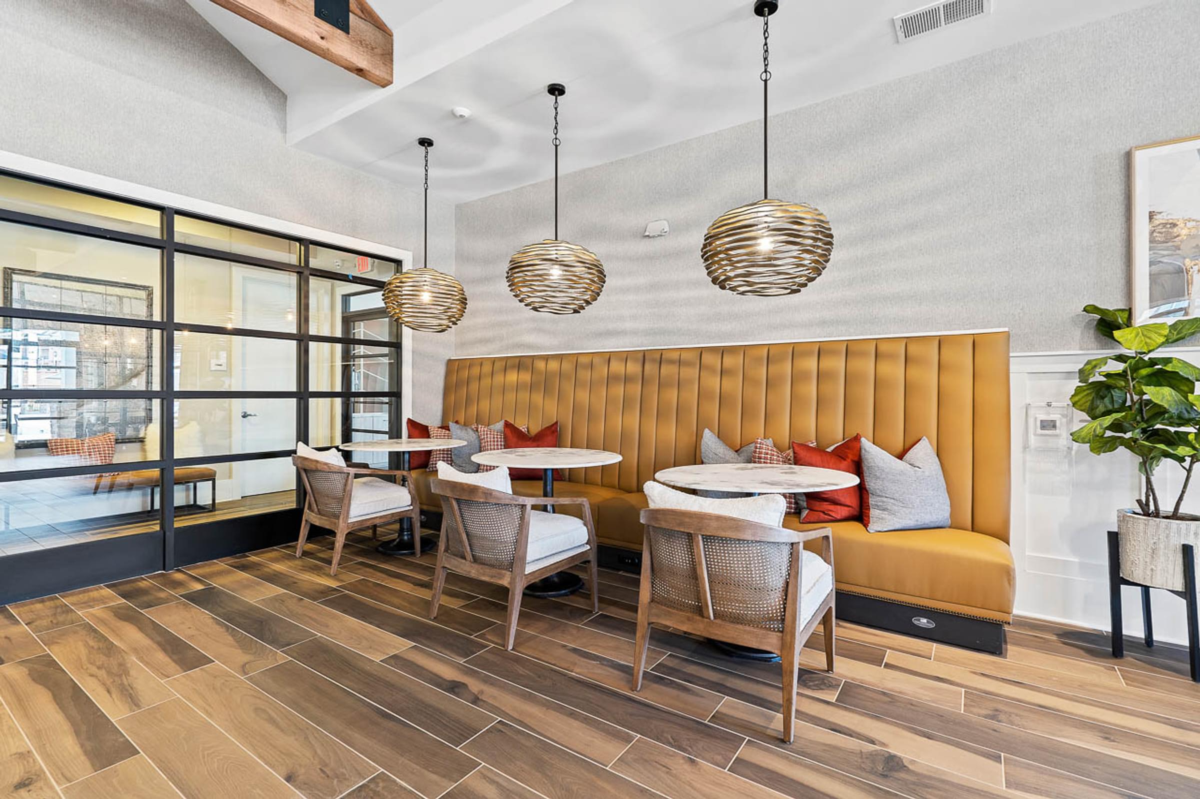 a dining room with a yellow couch and tables