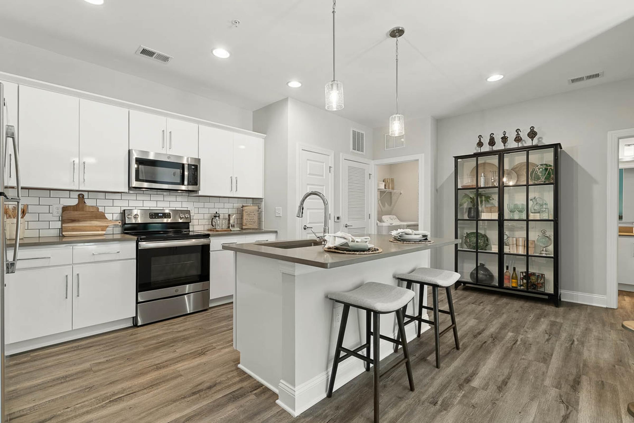 White Custom Cabinetry with Pendant Lights and Stainless Steel Appliances