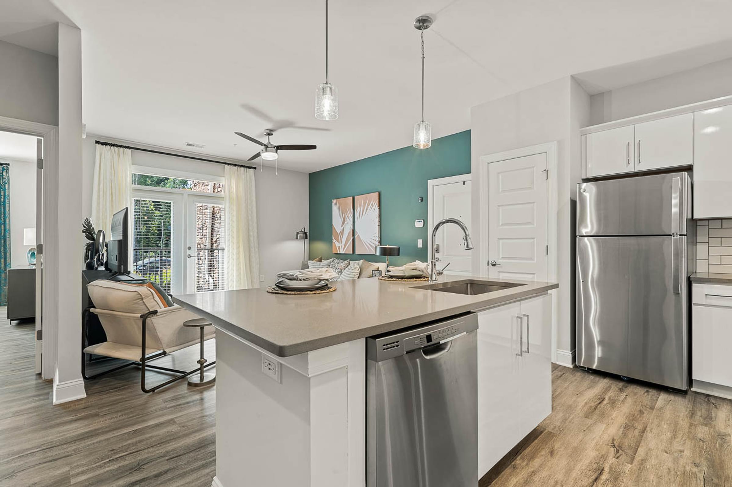 a kitchen with a large island and a stainless steel refrigerator