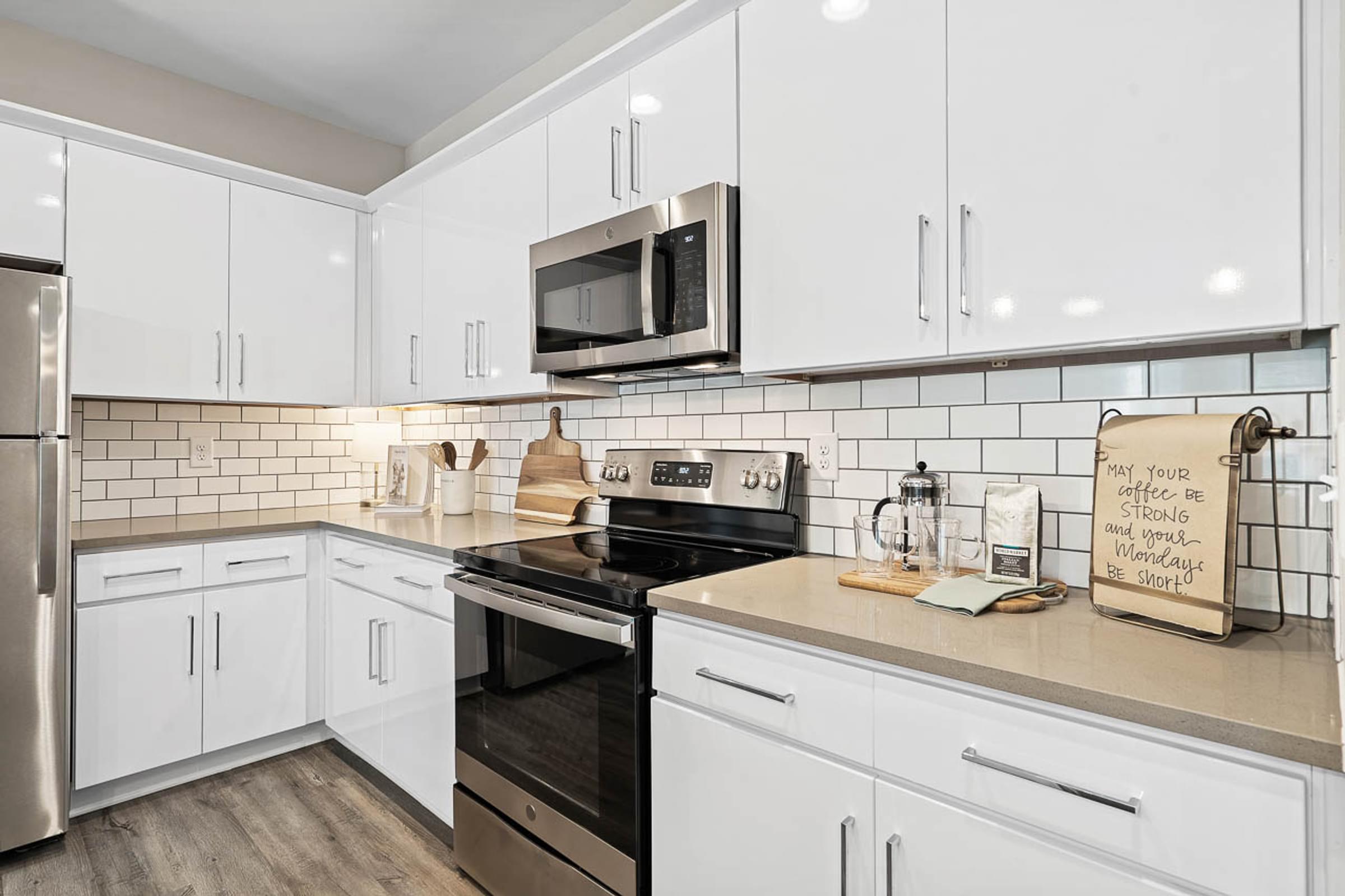 a white kitchen with a stove and a microwave