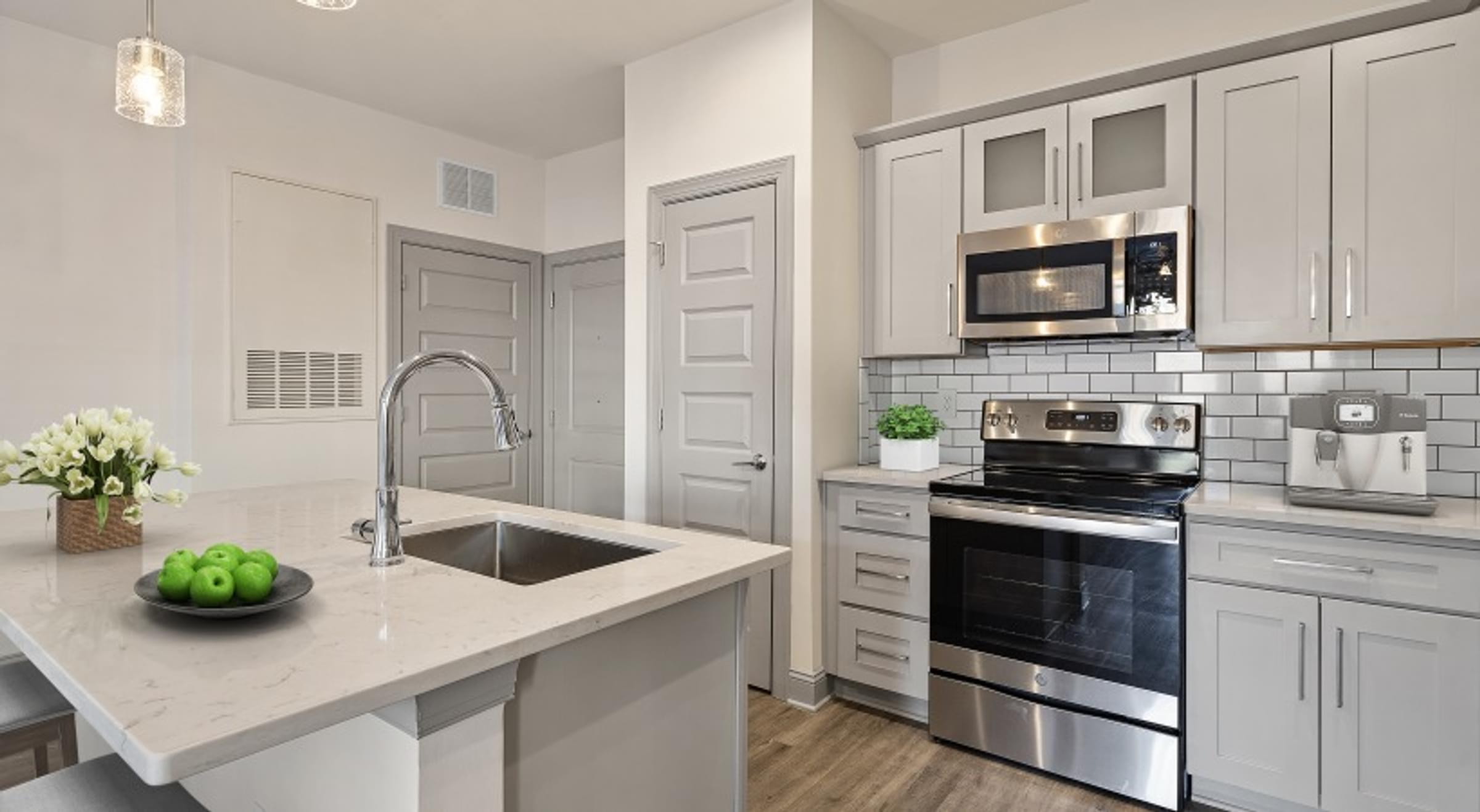 a kitchen with stainless steel appliances and a marble counter top