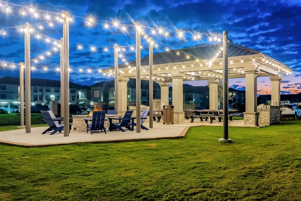 a patio with chairs and a pavilion with lights