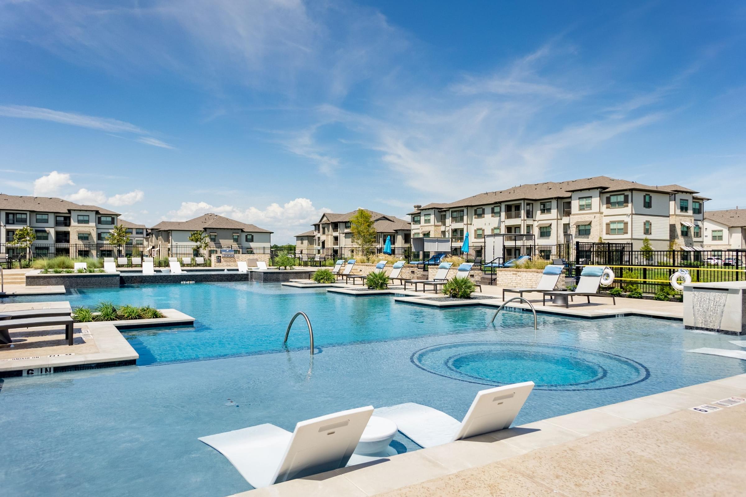 Resort-Style Saltwater Swimming Pool With Cushioned Lounge Furniture And Expansive Pool Deck
