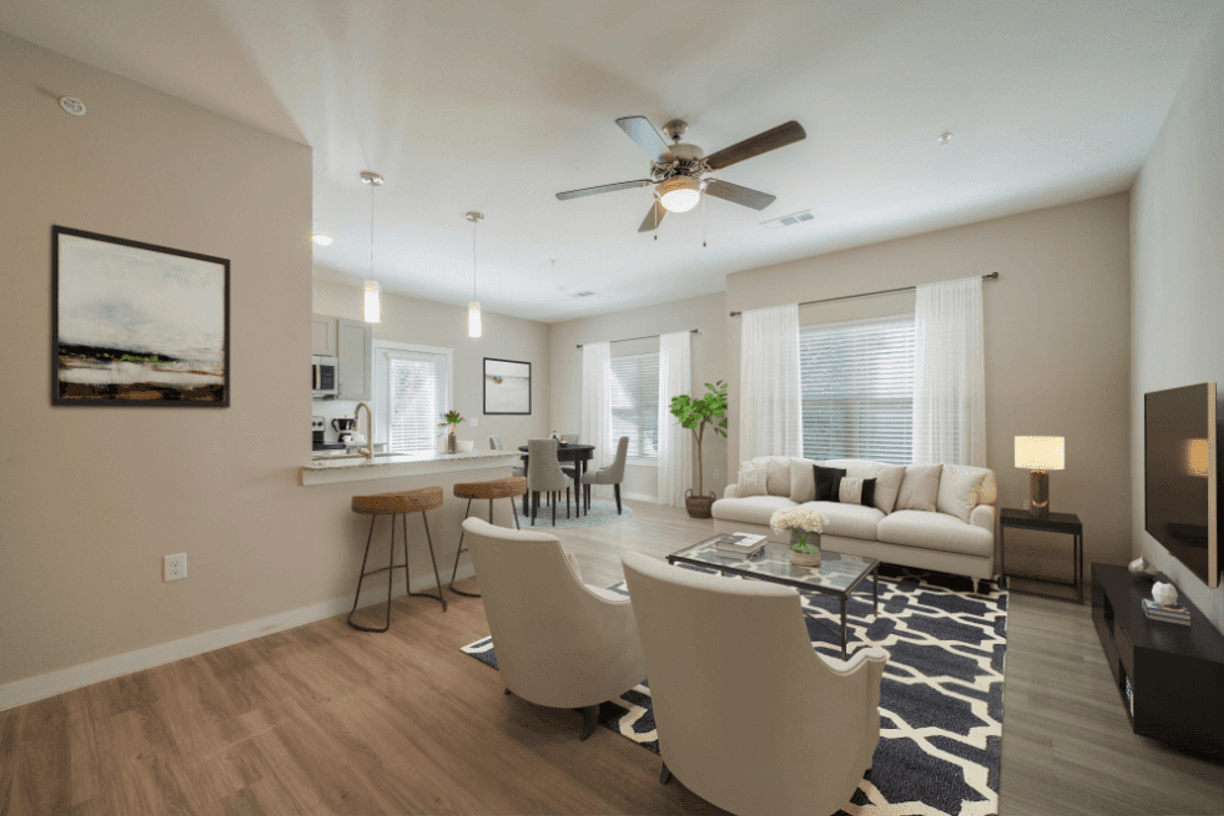 a living room with a ceiling fan and a couch and a table with chairs