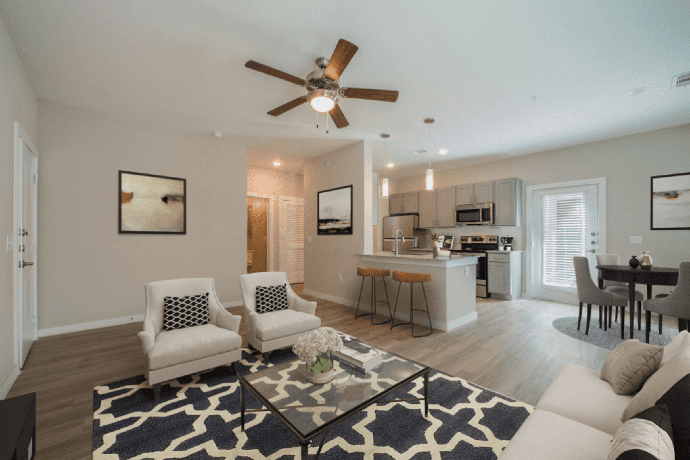 an open living room and kitchen with a ceiling fan