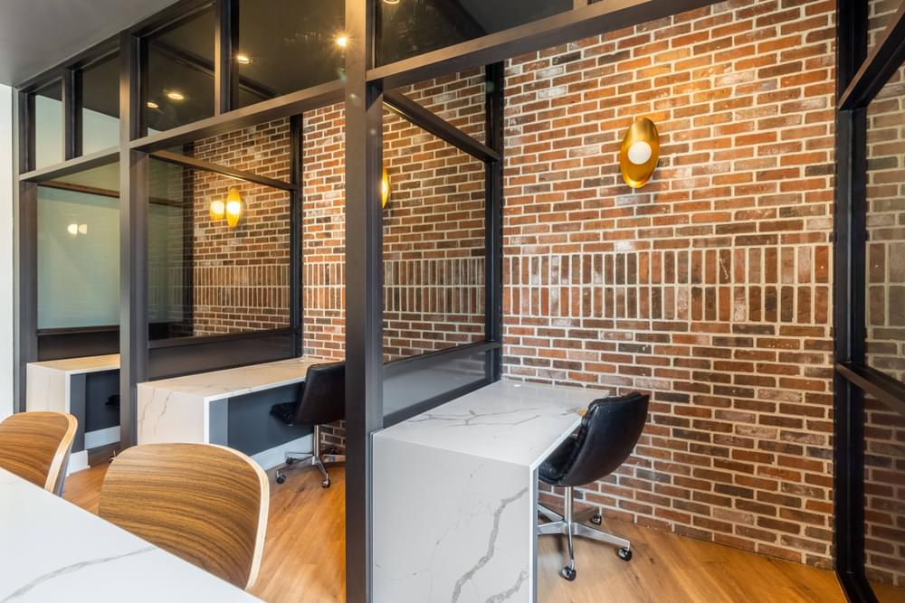 a room with a table and chairs and a brick wall