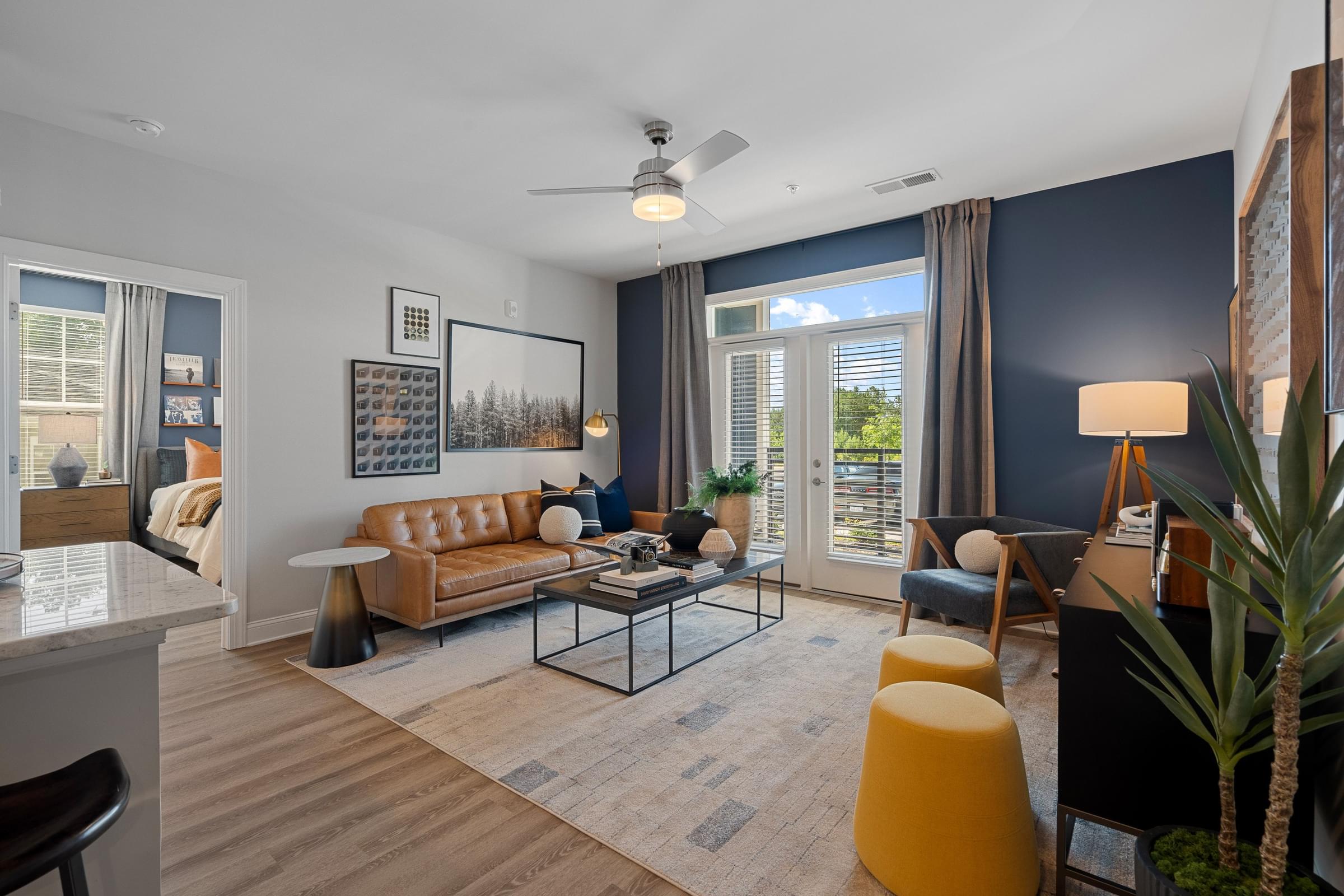 a living room with a couch coffee table and chair and a large window with a view of