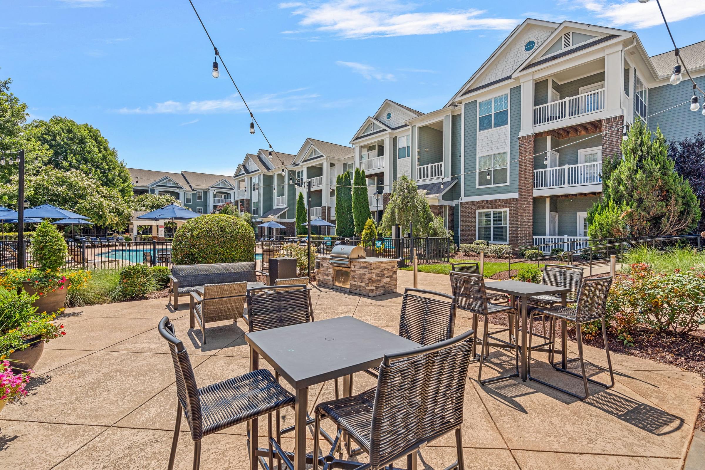 A patio with a table and chairs is surrounded by apartment buildings.