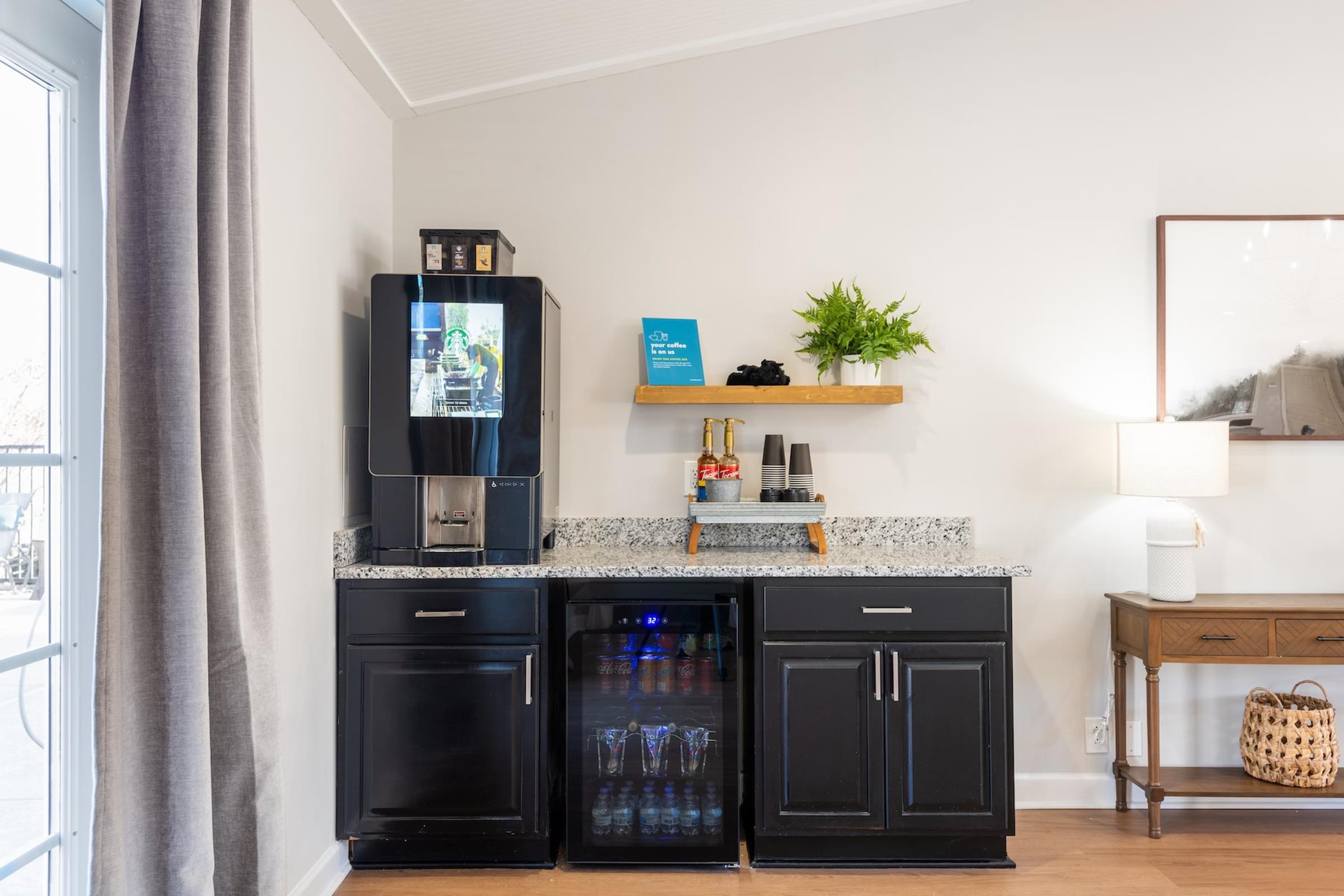 A black fridge and freezer in a kitchen with a TV on top