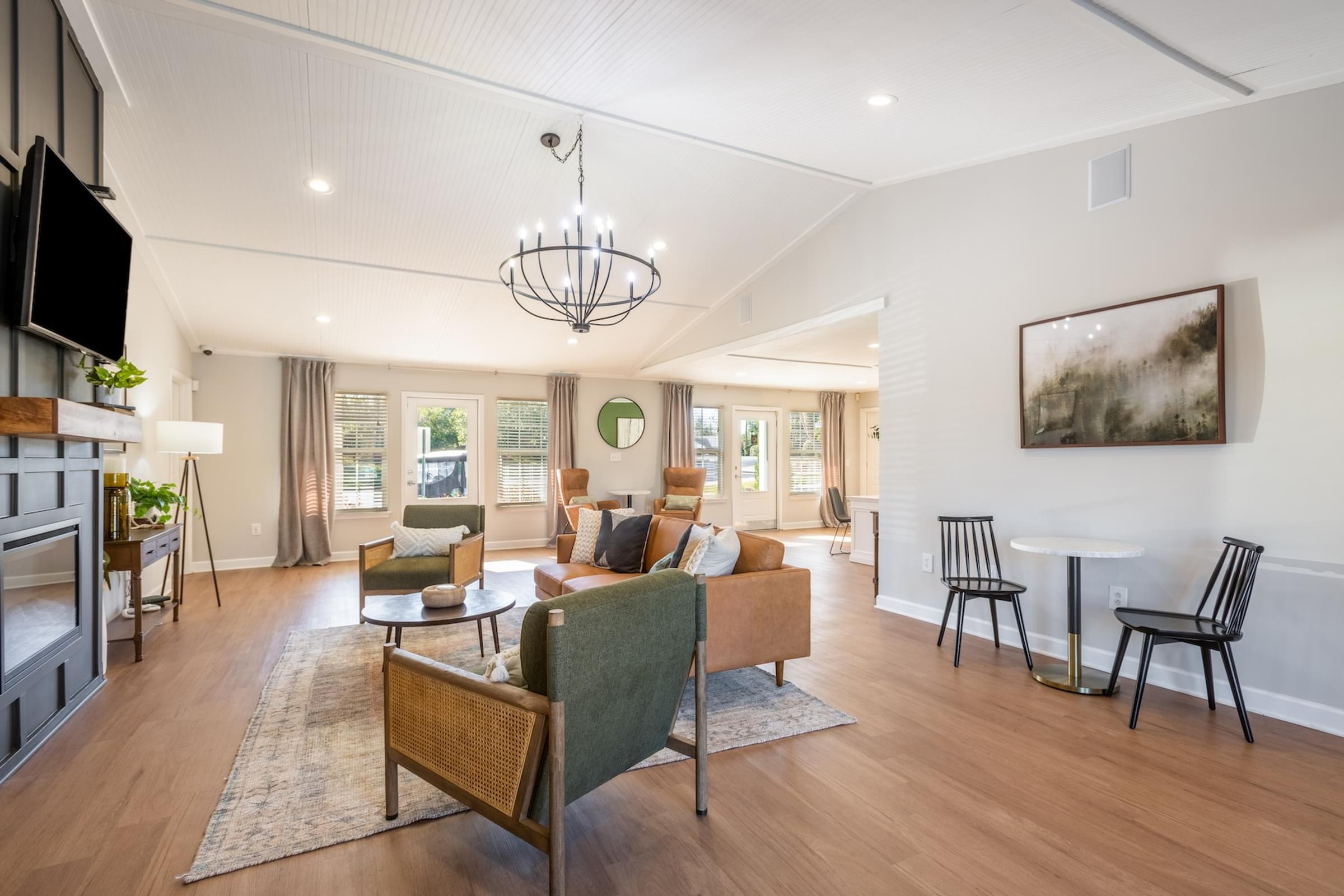 A living room with a couch, chairs, and a television