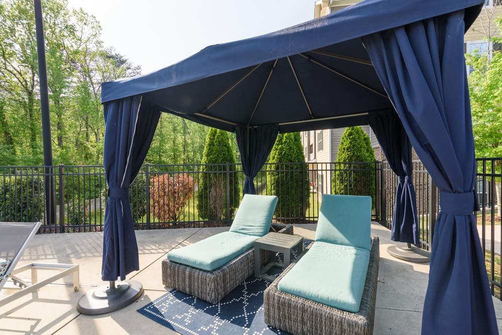 a gazebo with two couches and a table on a patio
