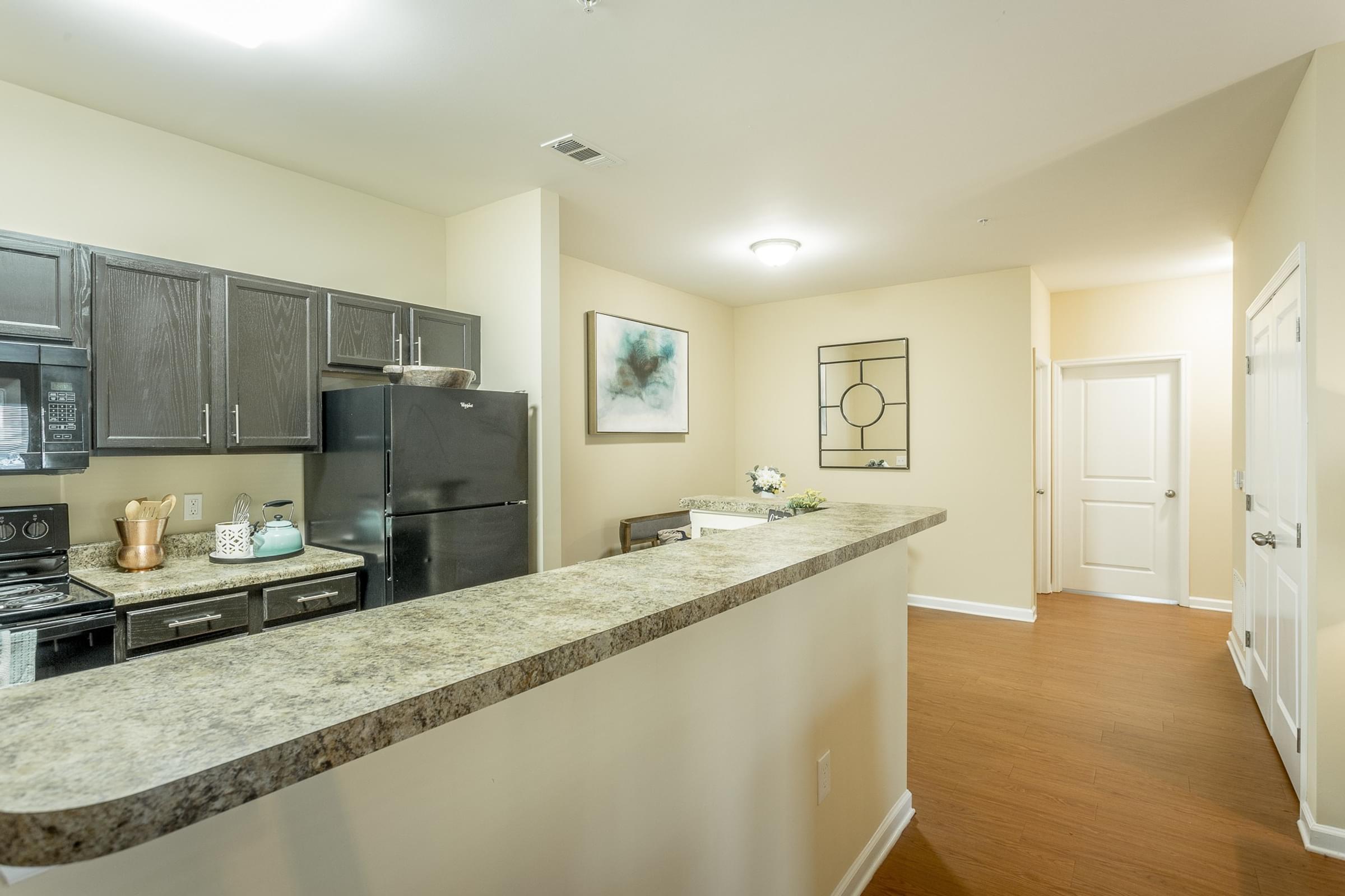 a kitchen with a granite counter top and a black refrigerator