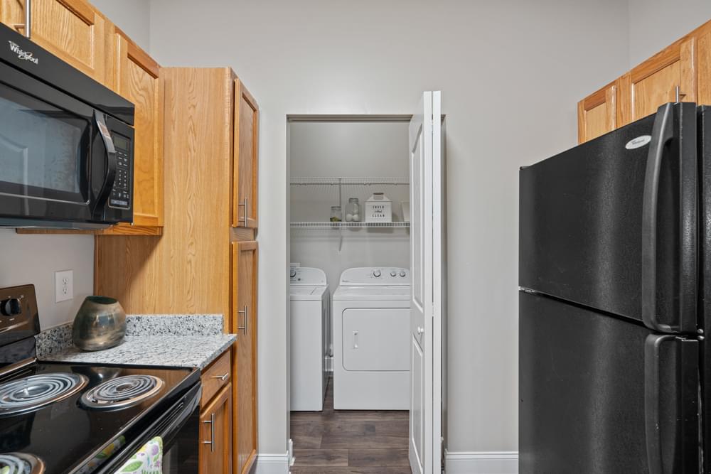 a kitchen with a refrigerator freezer and a washer and dryer