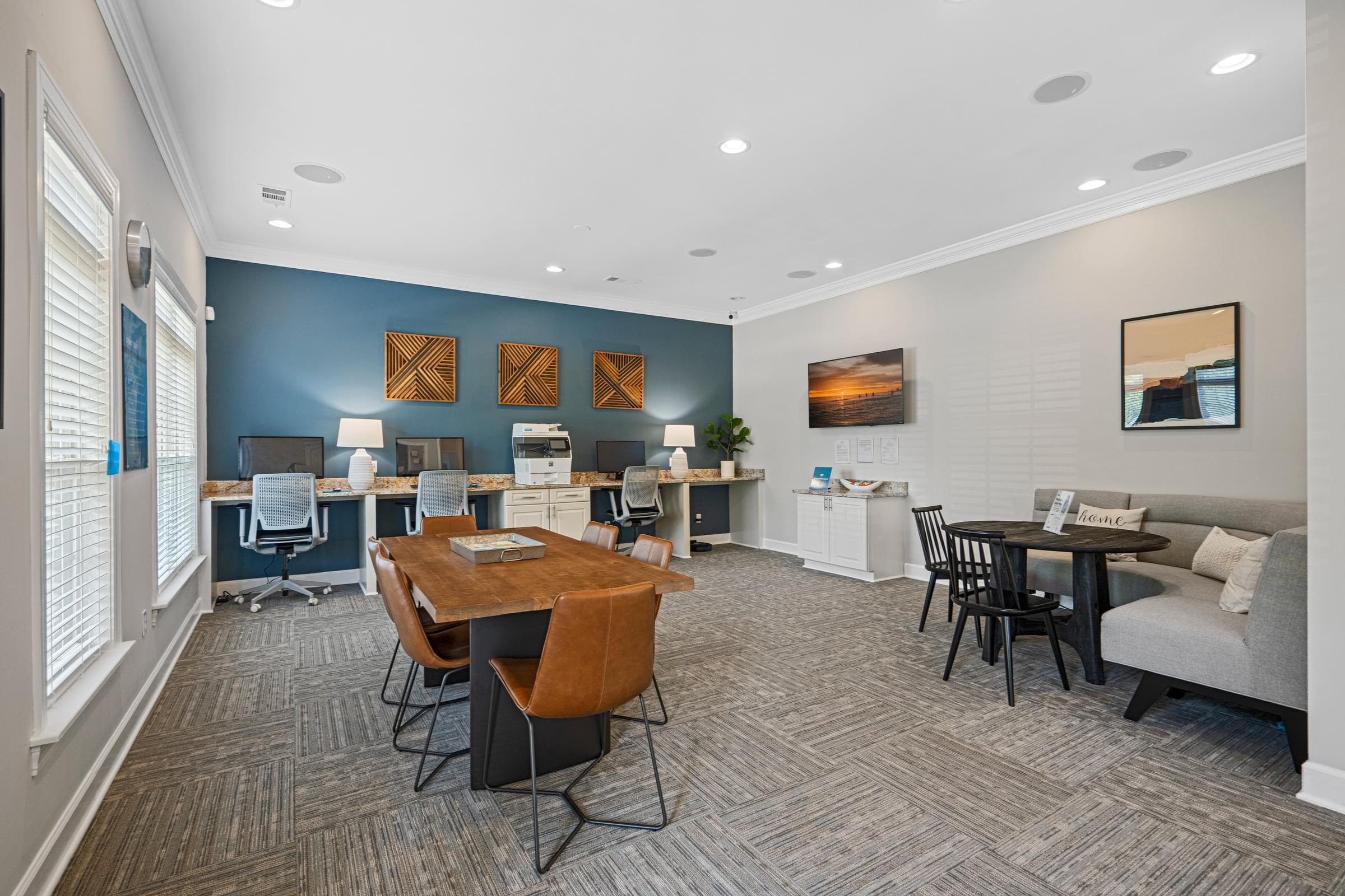 a common room with desks and chairs and a couch
