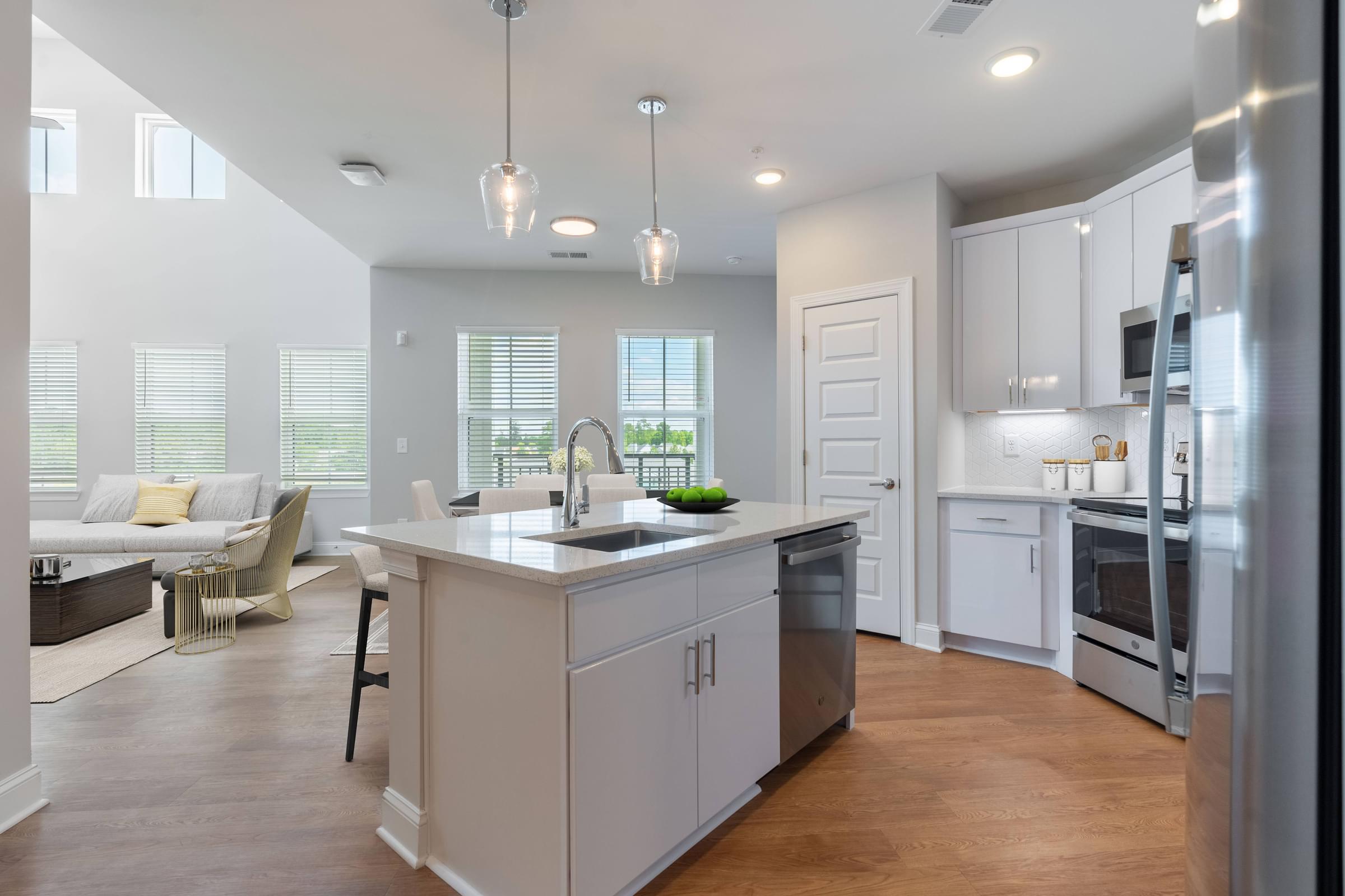 a kitchen and living room with white cabinets and a counter top