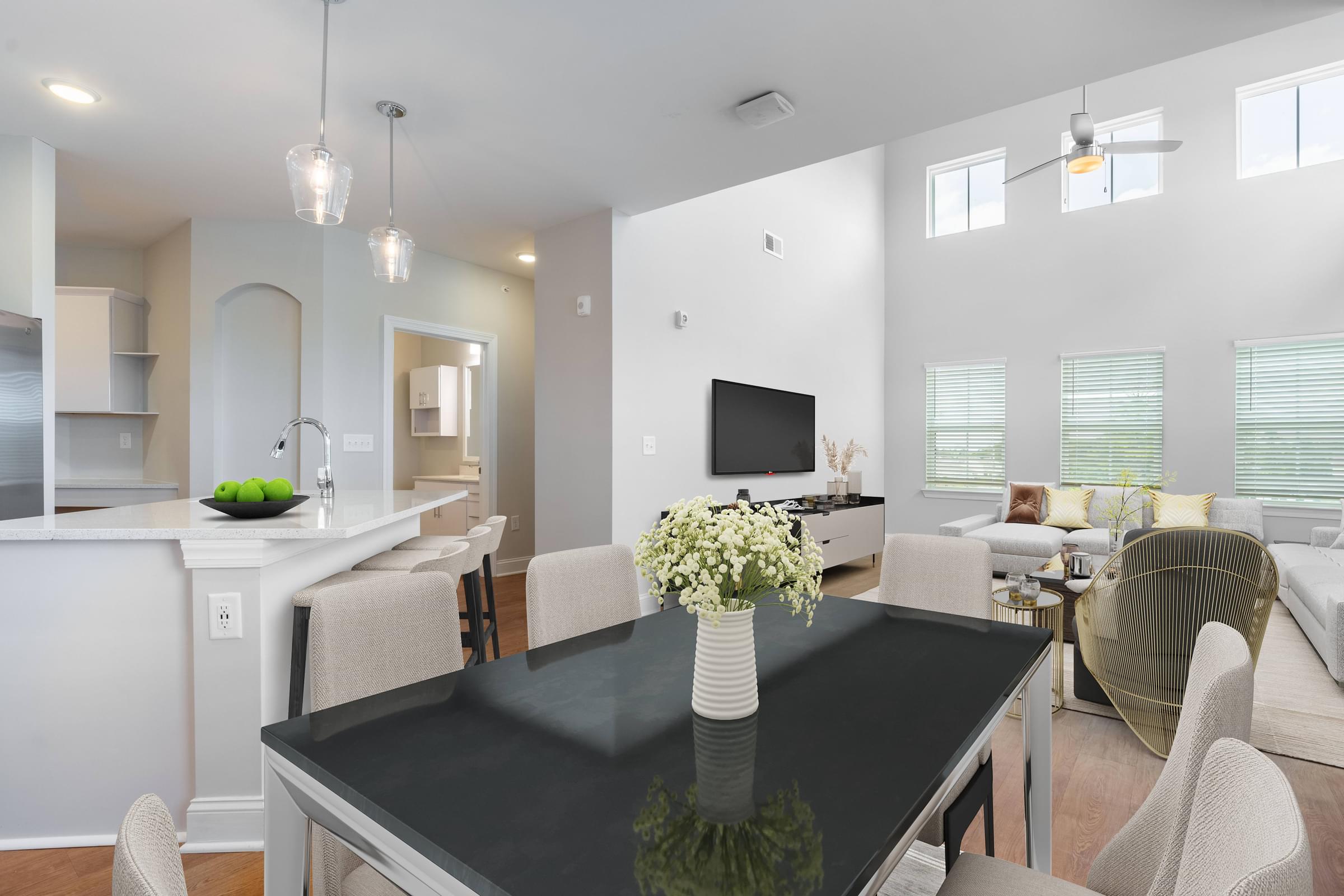 a living room and dining room with a table and chairs