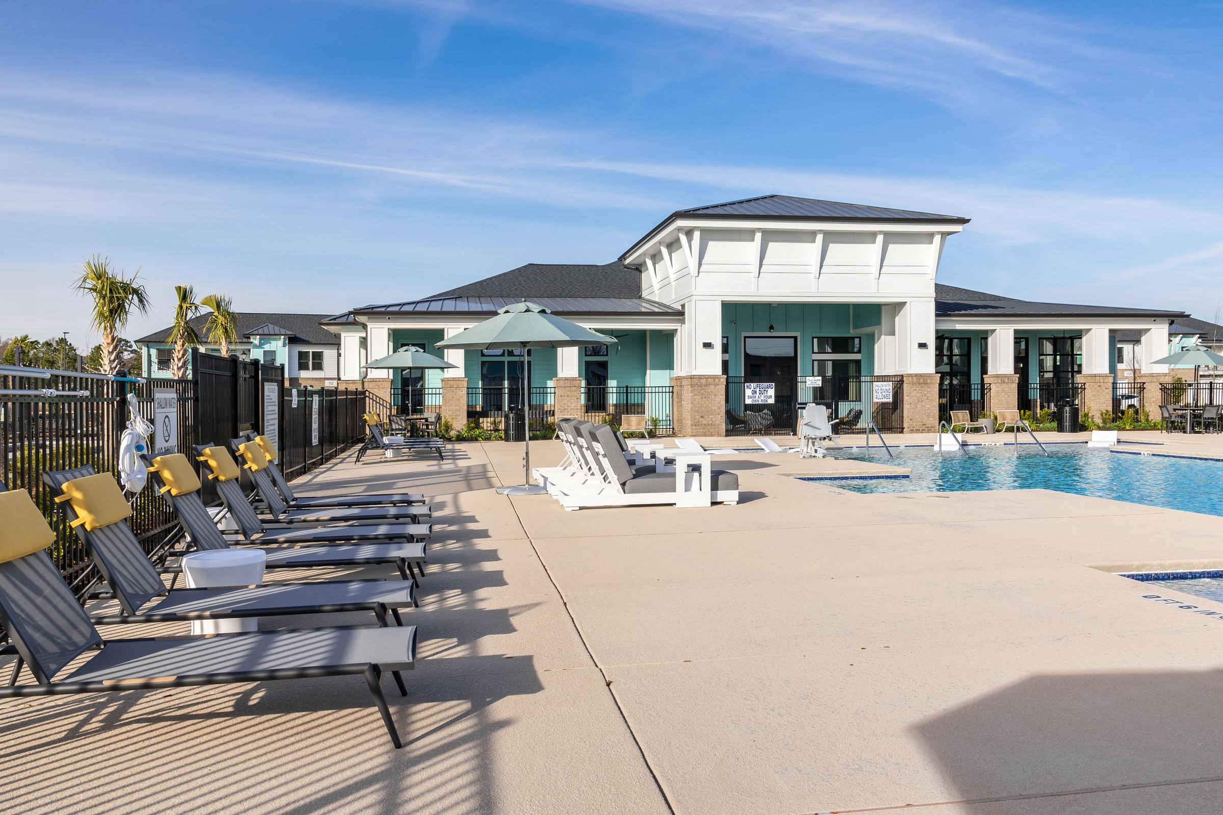 a pool with lounge chairs and a building in the background