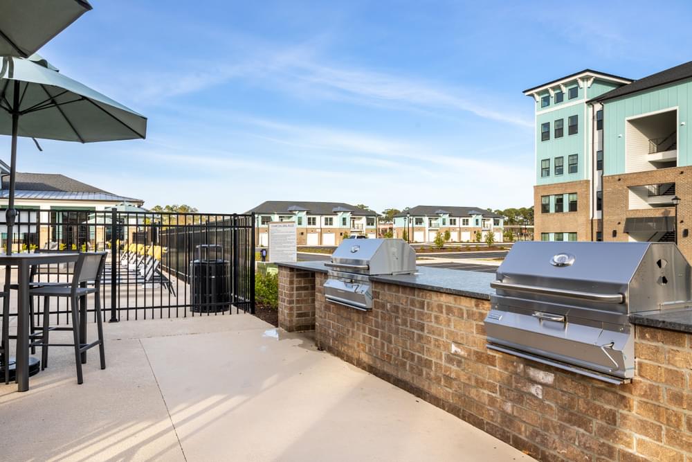the club at highland park apartments patio and outdoor seating area with grill and tables