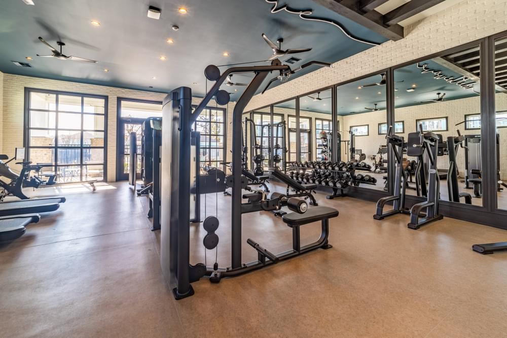 a gym with weights and other exercise equipment and glass doors