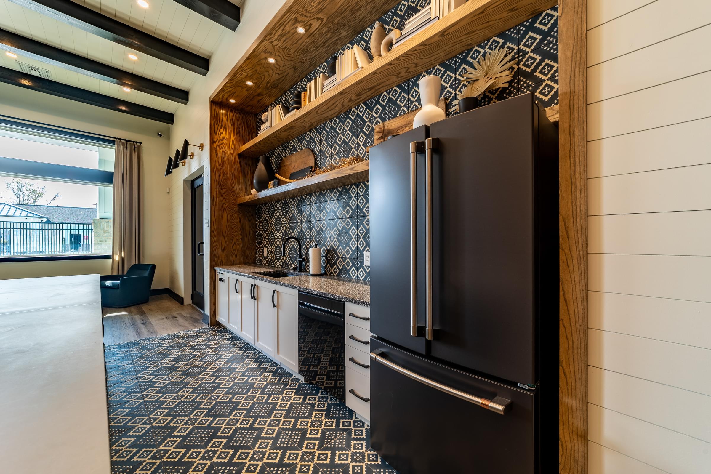 a kitchen with black appliances and a blue and white rug
