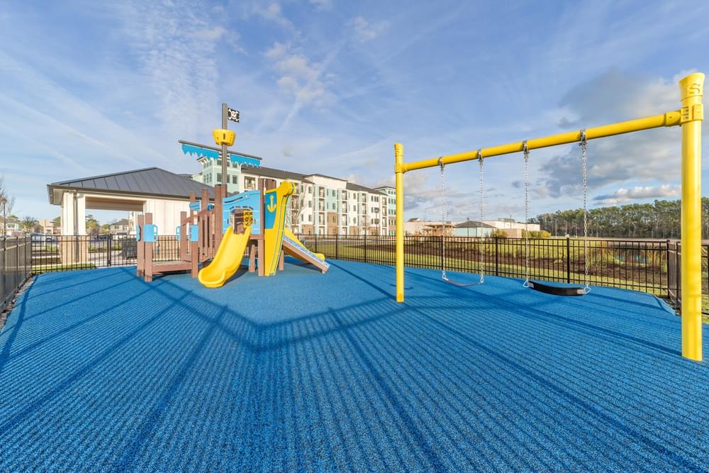 a playground with a swing set and slides on a blue floor