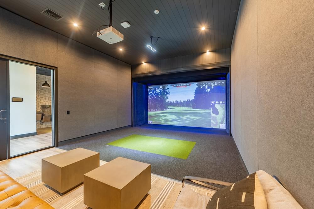 a living room with a projector screen in the back of it