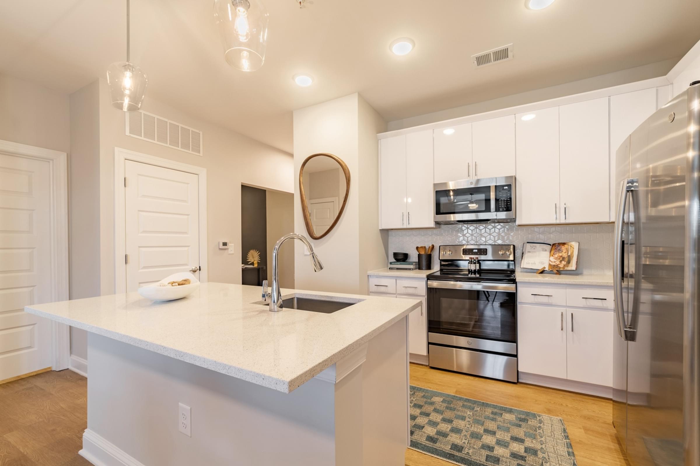 A modern kitchen with a large island and stainless steel appliances.