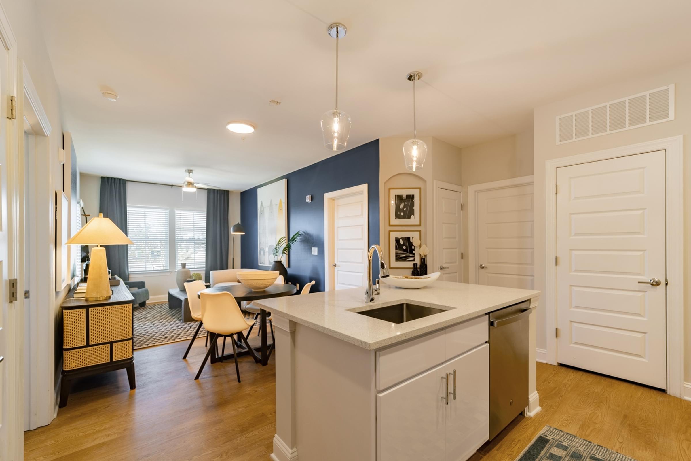 A kitchen with a white counter top and a sink.